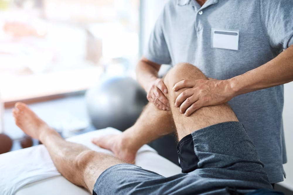A physical therapist manipulating a patient's leg