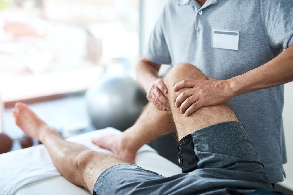 A physical therapist manipulating a patient's leg