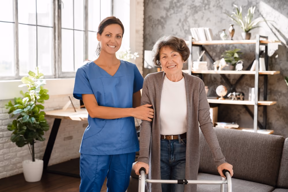 A woman with a walker being assisted by a health aide