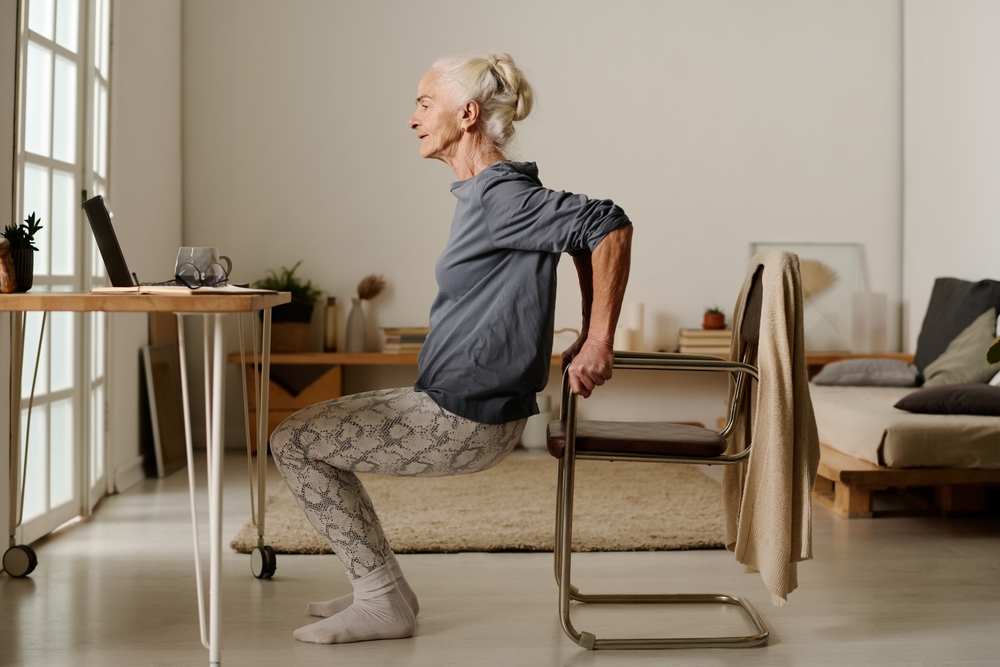 A senior woman performing a chair squat