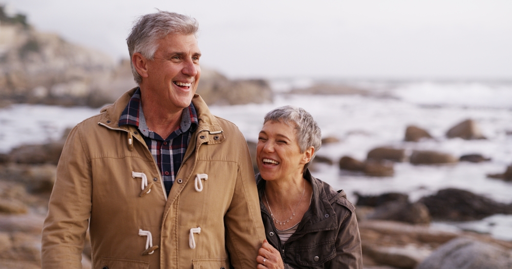 A man and a woman walking along the coast in winter.