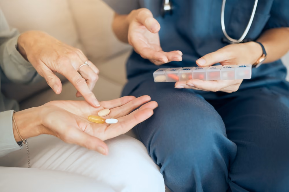 A senior citizen and a home health aid review their nmedcation.