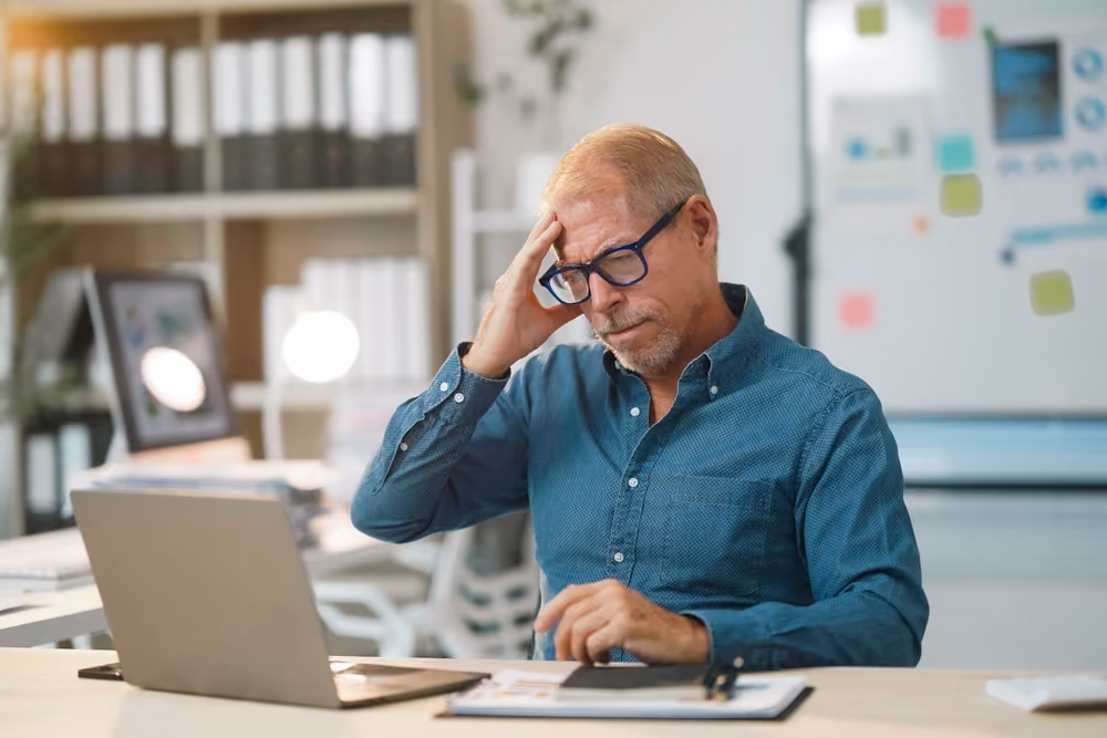 a middle aged man suffering a headache