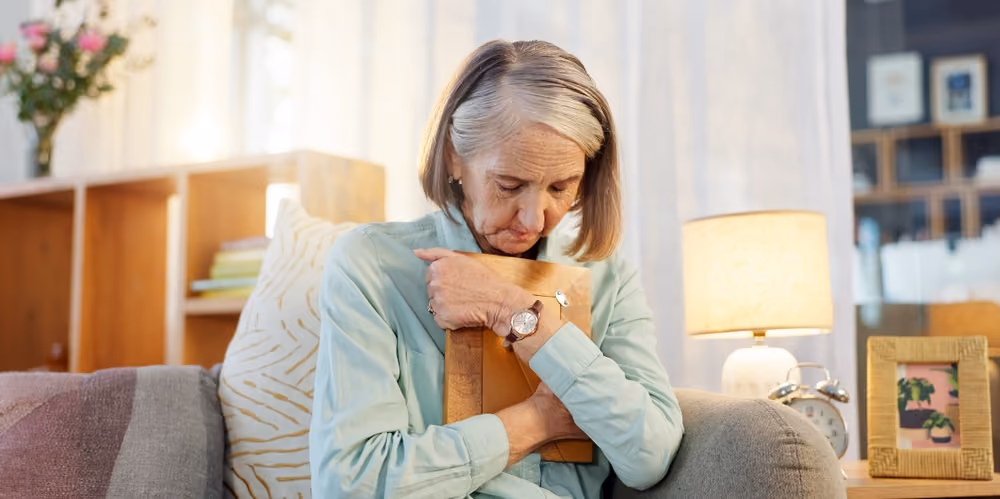 A woman grieving while holding a photograph.