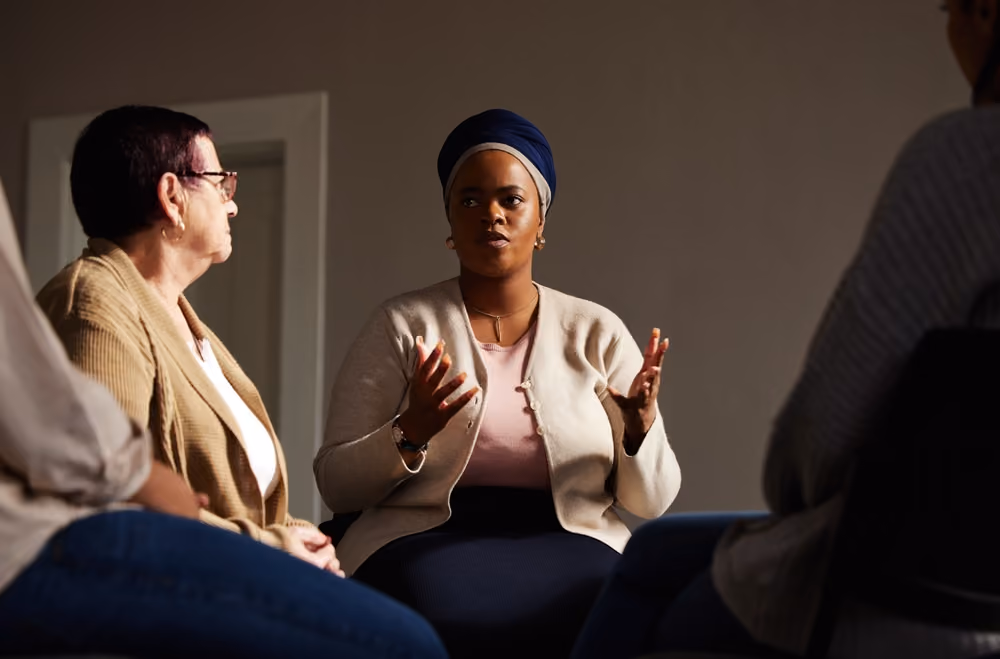 A woman talking to a grief support group.