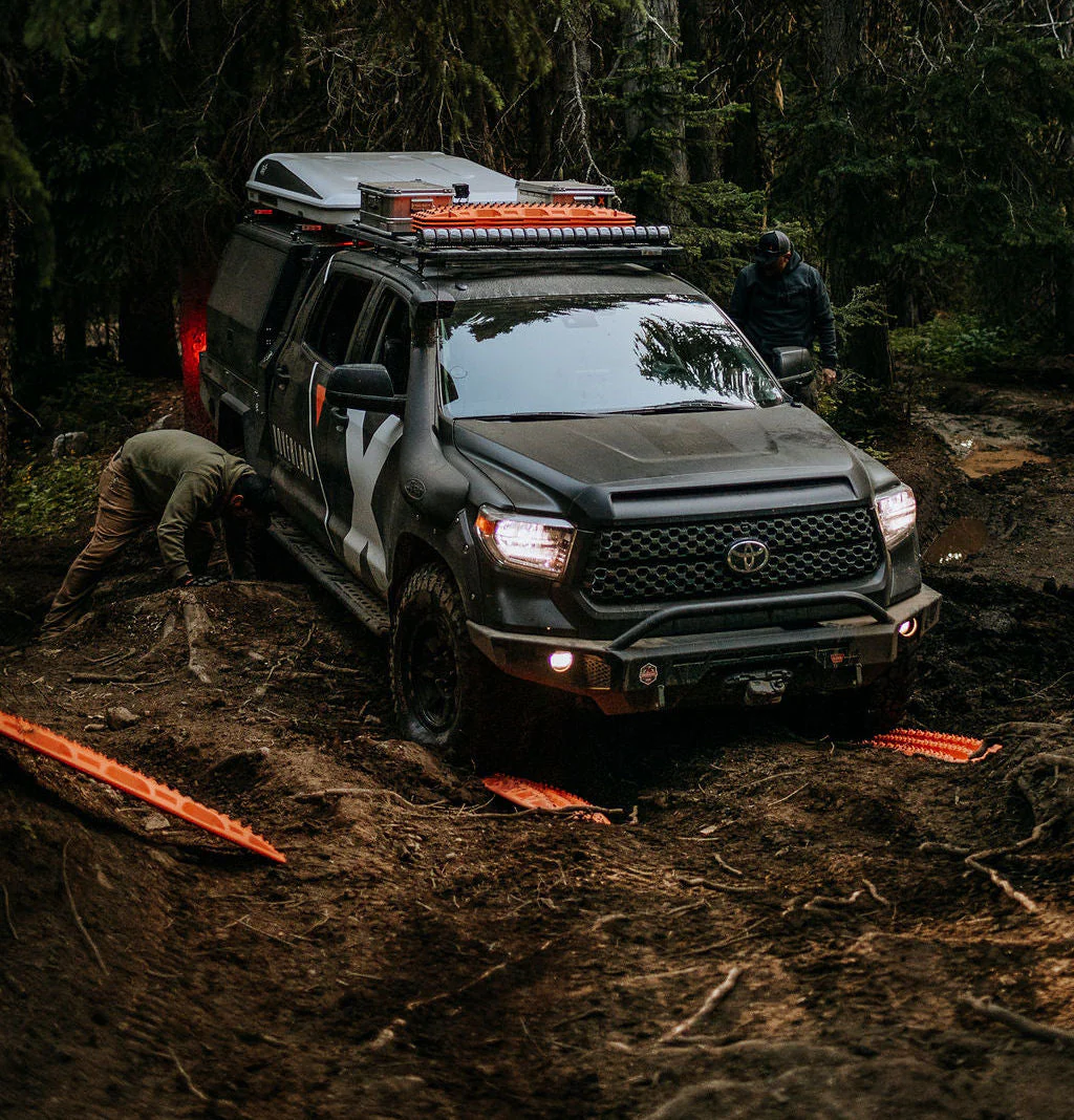 Orange maxtraxs used an offroad recovery of an overland vehicle on the trail