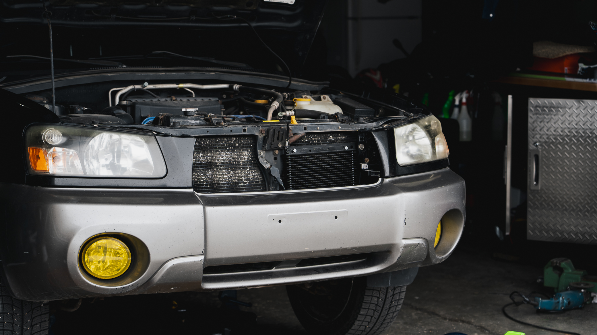 A lifted Subaru Forester with modifications being installed