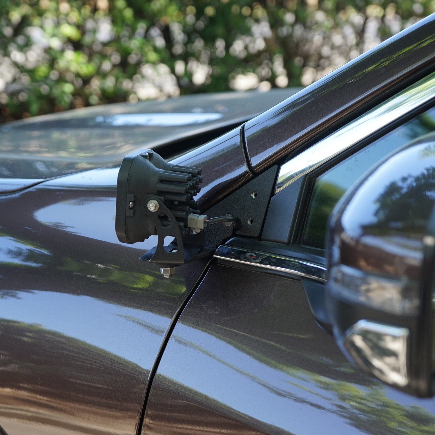 SMK Fabrication ditch light bracket installed on Subaru Outback hood hinge