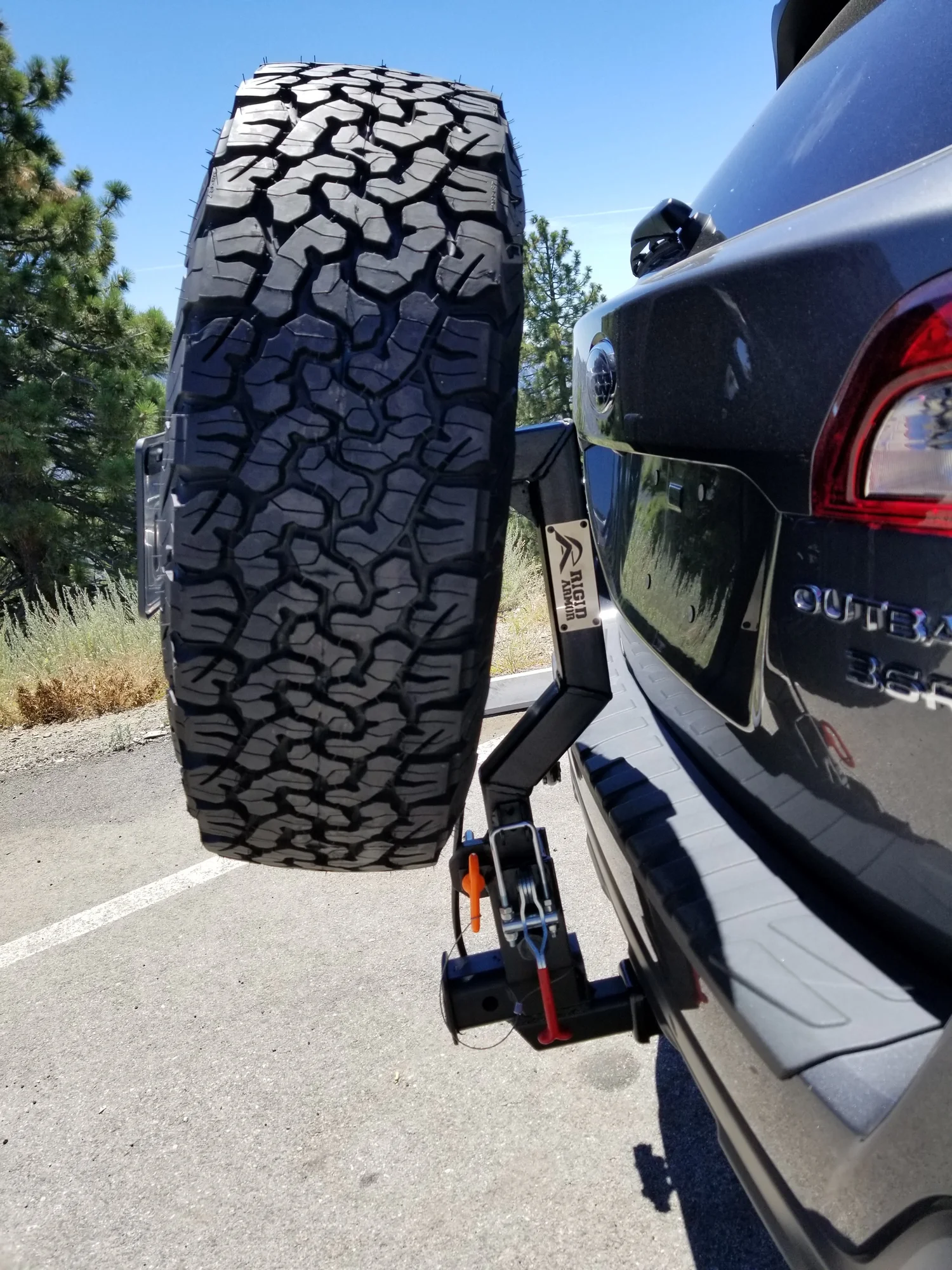 Subaru Outback with Rigid Armor spare tire hitch carrier and off-road tire mounted at the rear