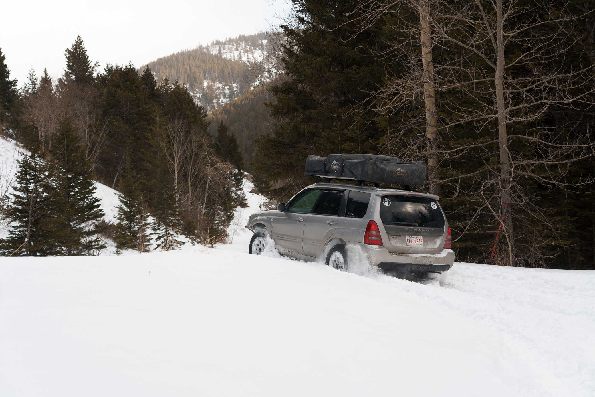 2004 lifted Subaru Forester going though deep snow with a roof top tent