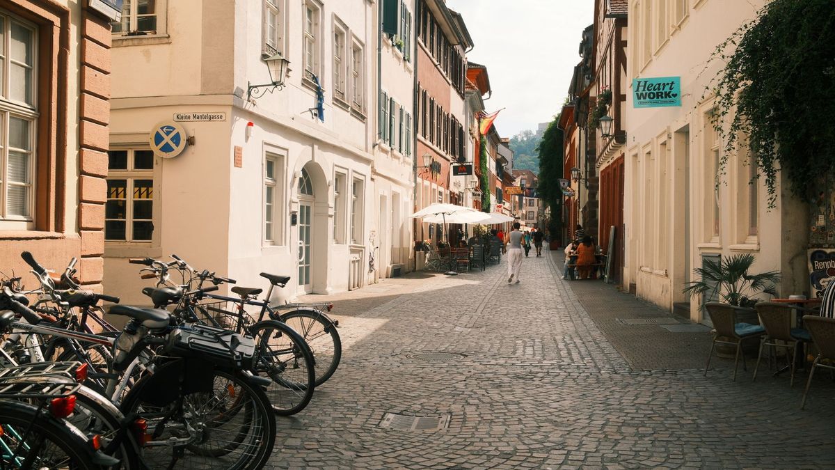 Enge Gasse in der Heidelberger Altstadt mit abgestellten Fahrrädern und Cafétischen