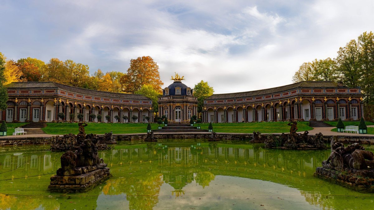 Das Neue Schloss der Eremitage in Bayreuth spiegelt sich im Herbst in einem Teich
