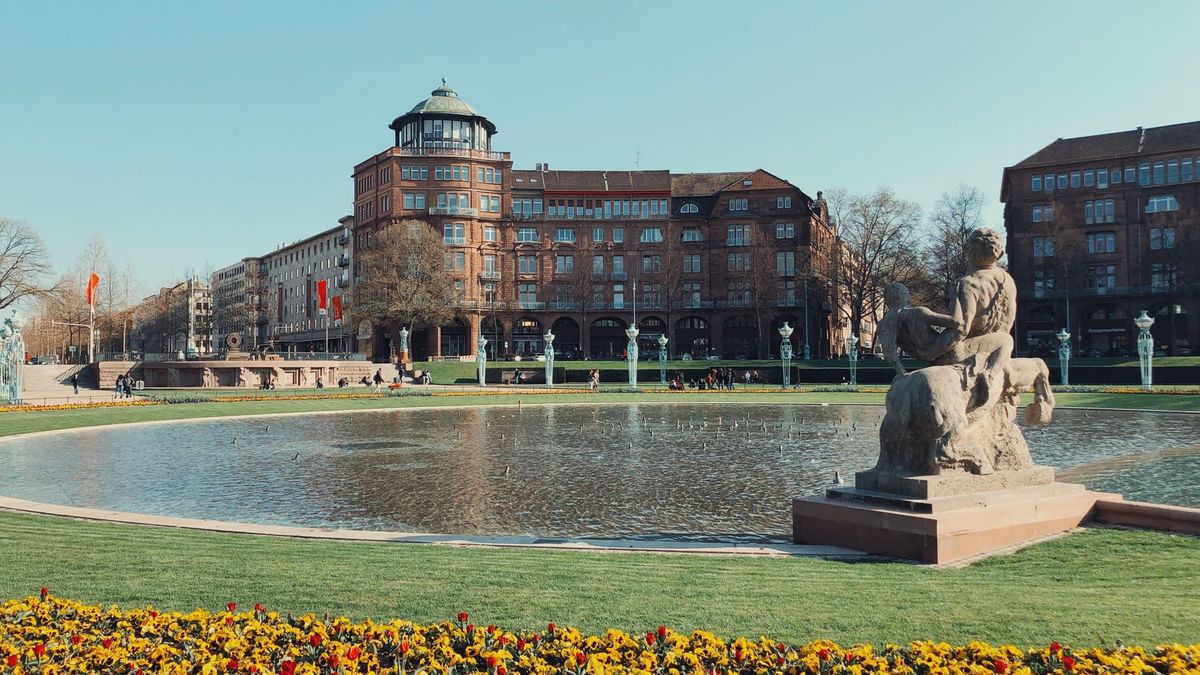 Der Friedrichsplatz in Mannheim mit Wasserbecken, Skulptur und blühenden Beeten
