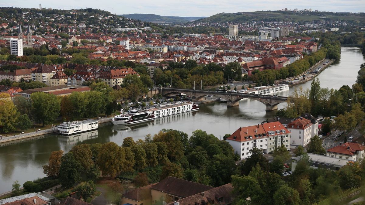 Blick über die Dächer von Würzburg auf den Main mit Brücke und Ausflugsschiffen