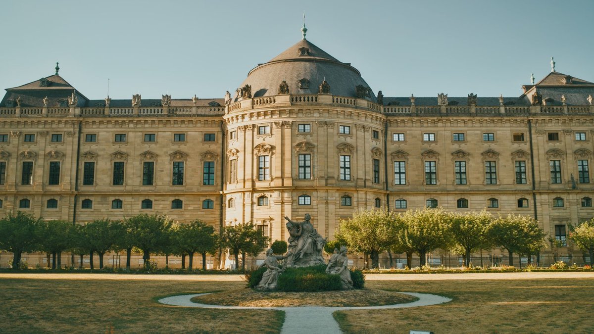 Barocke Fassade der Würzburger Residenz mit Brunnen und Hofgarten davor