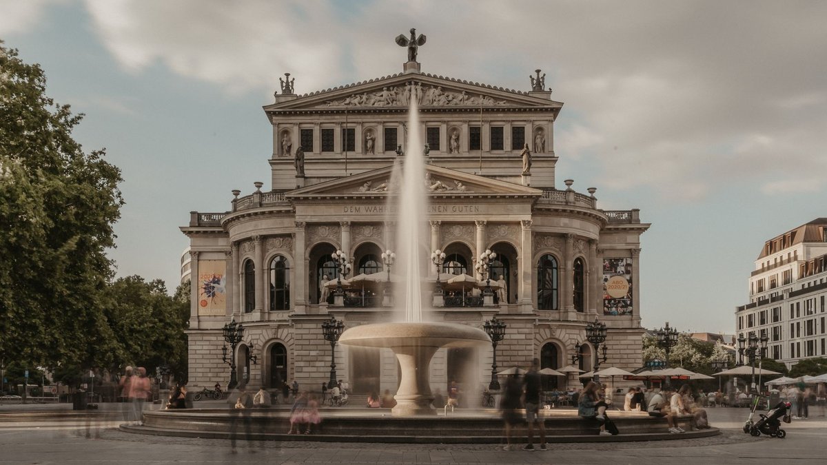 Die Alte Oper in Frankfurt mit dem Brunnen auf dem Opernplatz und Menschen davor