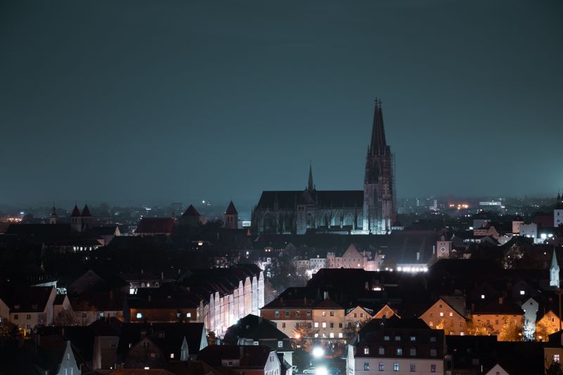 Regensburg bei Nacht mit beleuchteten Dächern der Altstadt und dem Dom über der Stadtsilhouette