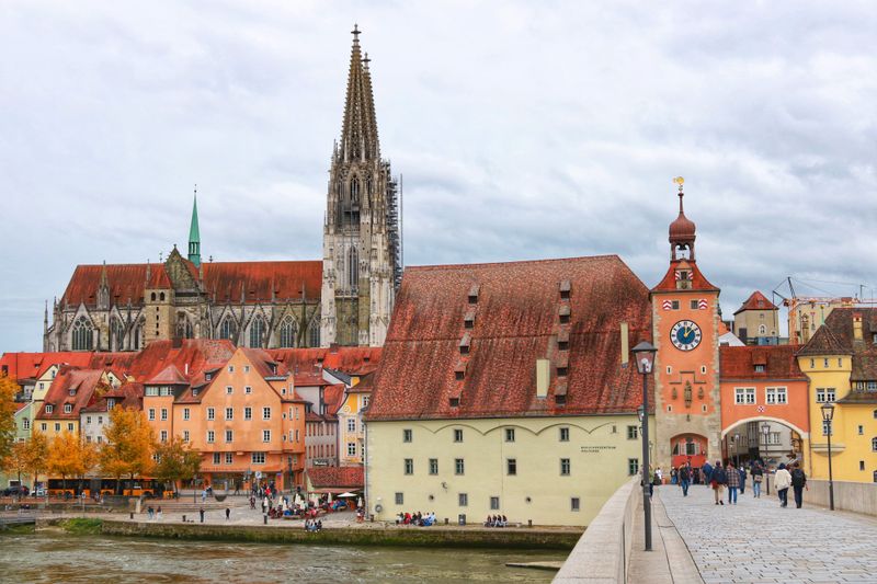 Regensburger Altstadt an der Donau mit Dom, Salzstadel und Brückturm, Menschen auf der Steinernen Brücke