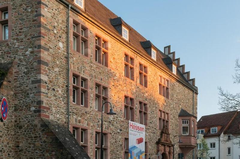 Das Alte Schloss in Gießen im Abendlicht, ein wuchtiger Bau aus Bruchstein mit Treppengiebel