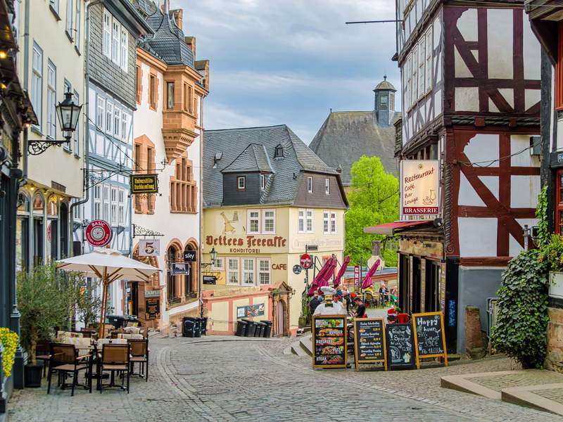 Platz in der Marburger Oberstadt mit Cafétischen, Fachwerkhäusern und Aufstellern