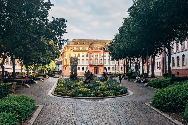 Barockes Palais in der Mainzer Innenstadt mit Blumenbeet und Kastanien davor