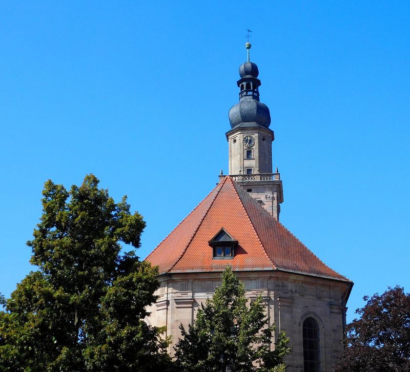 Turm der Altstädter Dreifaltigkeitskirche in Erlangen mit Zwiebelhaube vor blauem Himmel