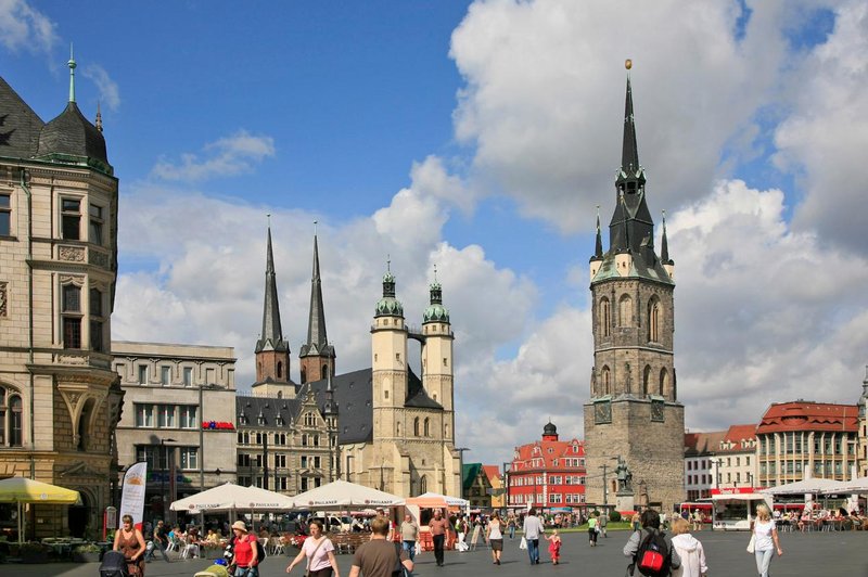 Marktplatz von Halle mit dem Roten Turm und den vier Türmen der Marktkirche, davor Marktstände und Passanten