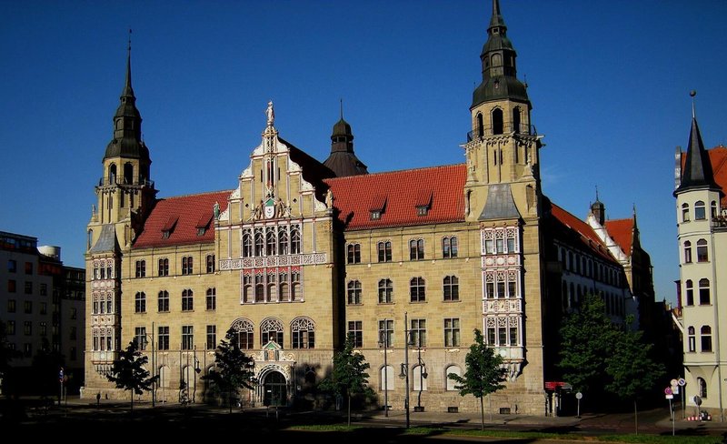 Historisches Gebäude des Landgerichts Halle mit zwei Türmen und rotem Ziegeldach unter blauem Himmel