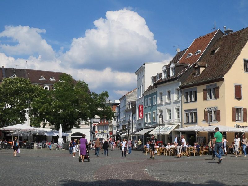 Belebter St. Johanner Markt in Saarbrücken mit Außengastronomie unter Sonnenschirmen