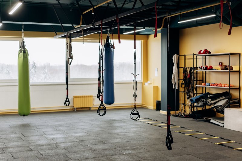 Leeres Fitnessstudio mit Boxsäcken und Trainingsgeräten