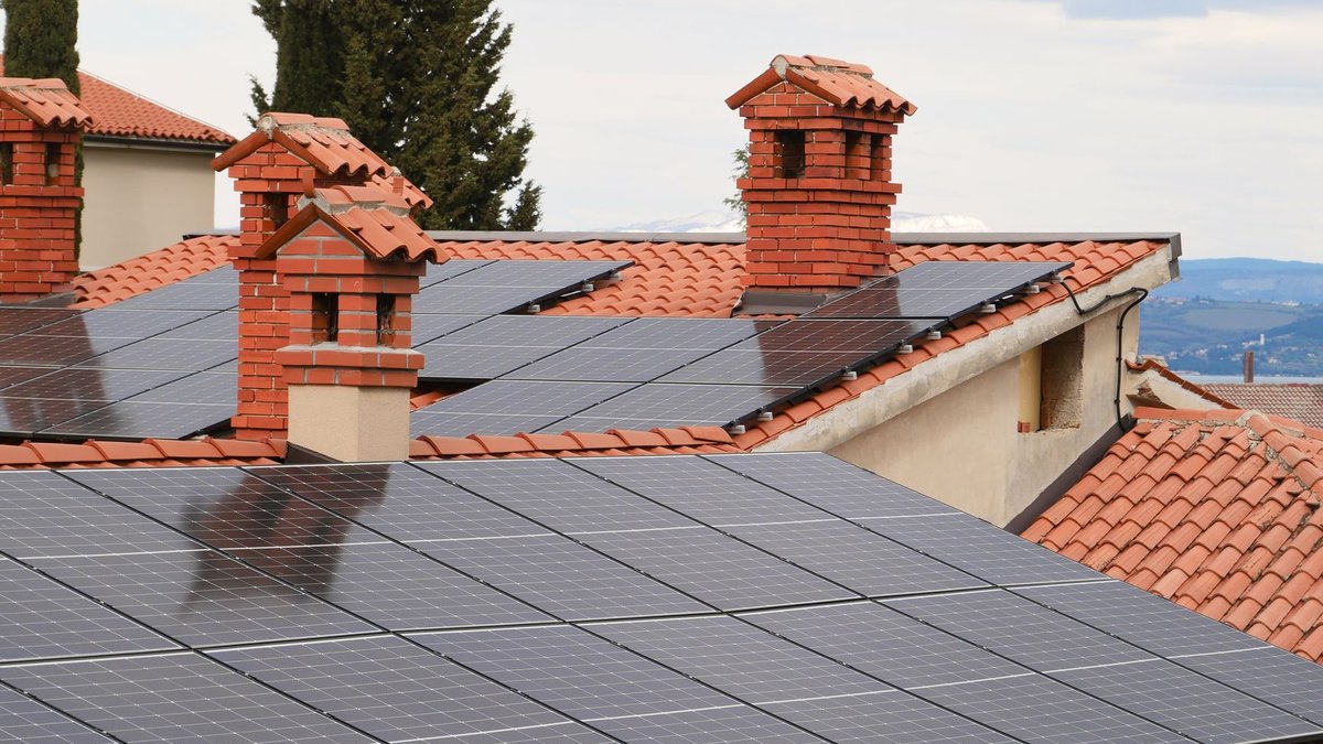 Photovoltaikmodule auf den Ziegeldächern mehrerer Wohnhäuser