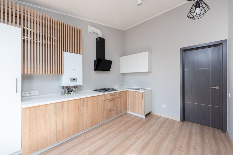 Eingebaute Küchenzeile mit Holzfronten in einer leeren Wohnung