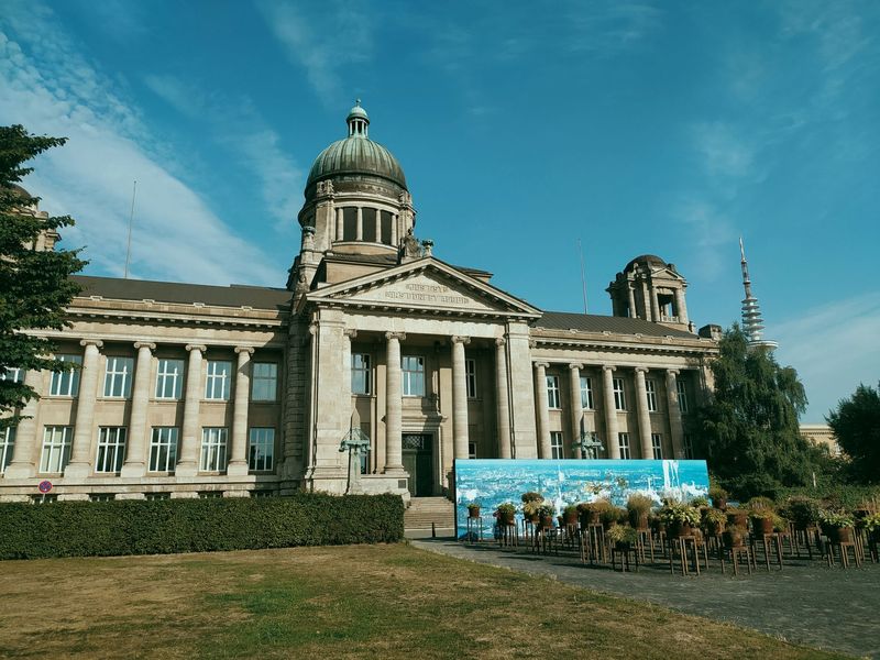 Historisches Gerichtsgebäude mit Säulenportikus und grüner Kuppel unter blauem Himmel