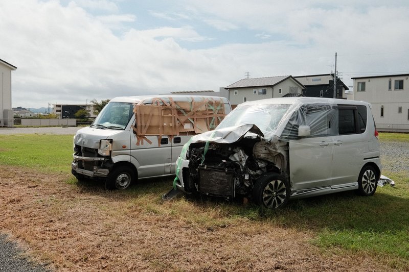 Zwei beschädigte Fahrzeuge stehen nach einem Unfall nebeneinander am Straßenrand