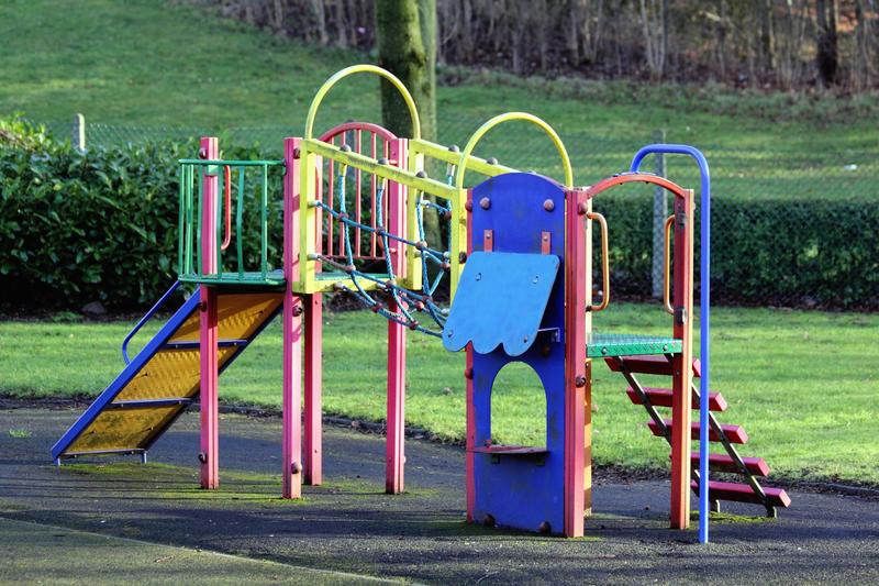 Spielgerät mit Rutsche und Klettergerüst auf einem leeren Spielplatz