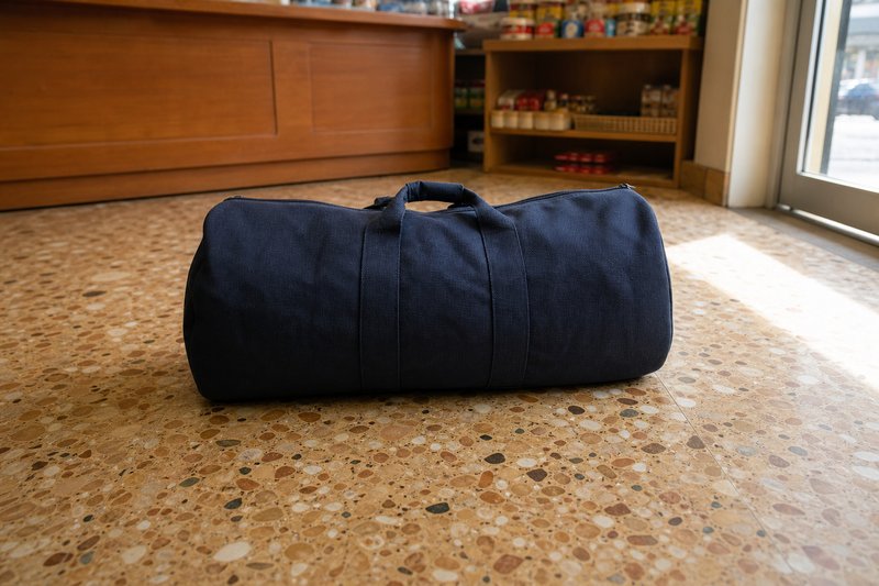 Dunkle Sporttasche steht allein auf dem Fliesenboden vor dem Verkaufstresen eines kleinen Ladens