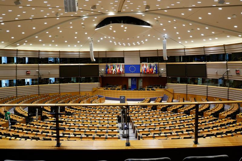 Halbrunder Plenarsaal des Europäischen Parlaments mit leeren Sitzreihen und Europaflaggen an der Stirnseite