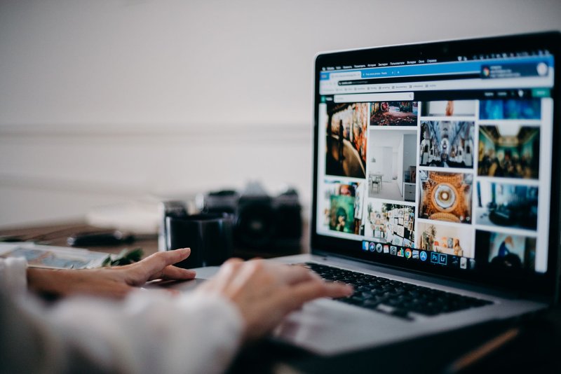 Person tippt am Laptop, auf dem Bildschirm eine Rasteransicht mit Bildtreffern