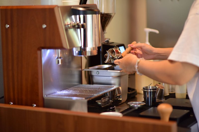 Barista setzt den Siebträger in eine Espressomaschine auf der Theke eines Cafés ein