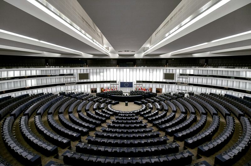 Halbrunder Plenarsaal des Europäischen Parlaments in Straßburg mit ansteigenden Sitzreihen, an der Stirnwand die Europaflagge und die Flaggen der Mitgliedstaaten