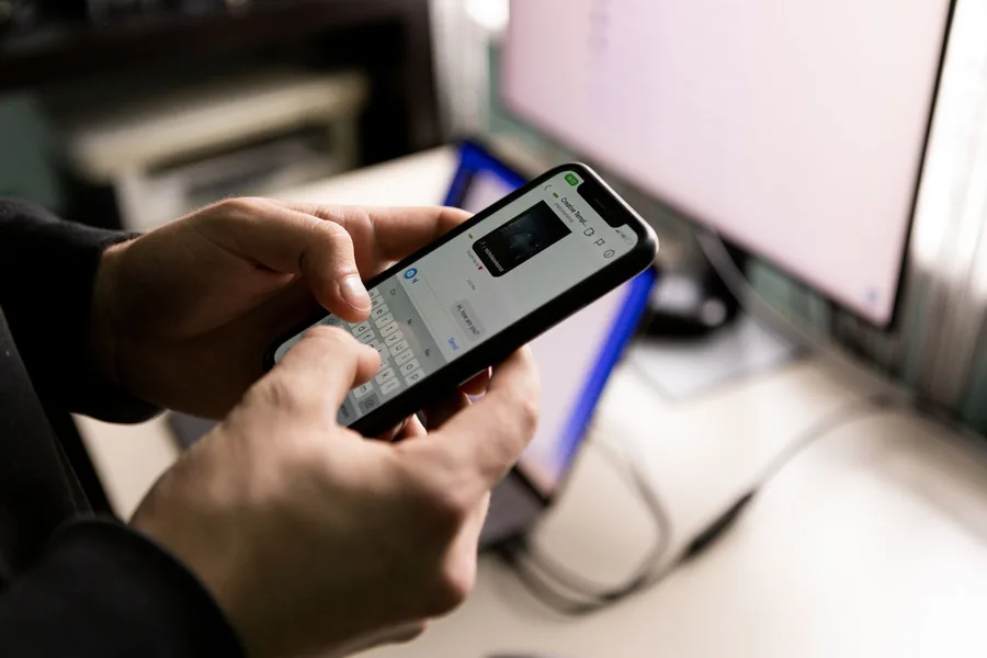 Hand hält ein Smartphone mit einer geöffneten Chat-Unterhaltung