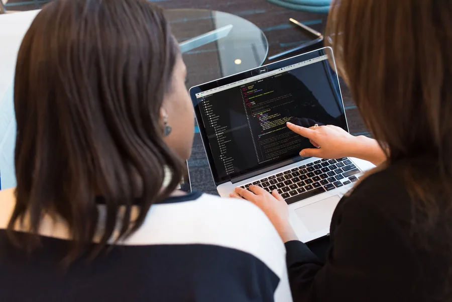 Zwei Frauen arbeiten gemeinsam an einem Laptop