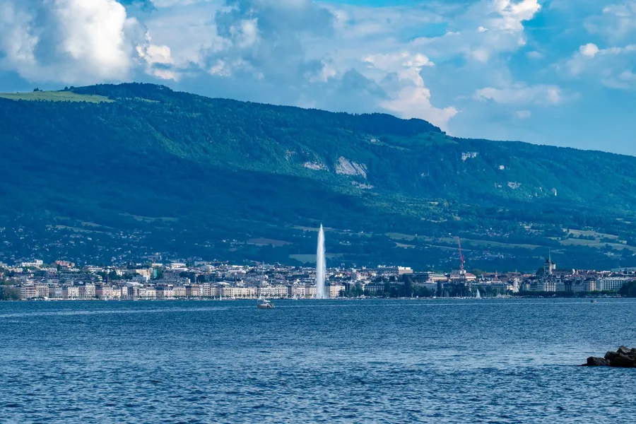 Blick über den Genfer See auf Genf mit der Fontäne Jet d'Eau bei Tag