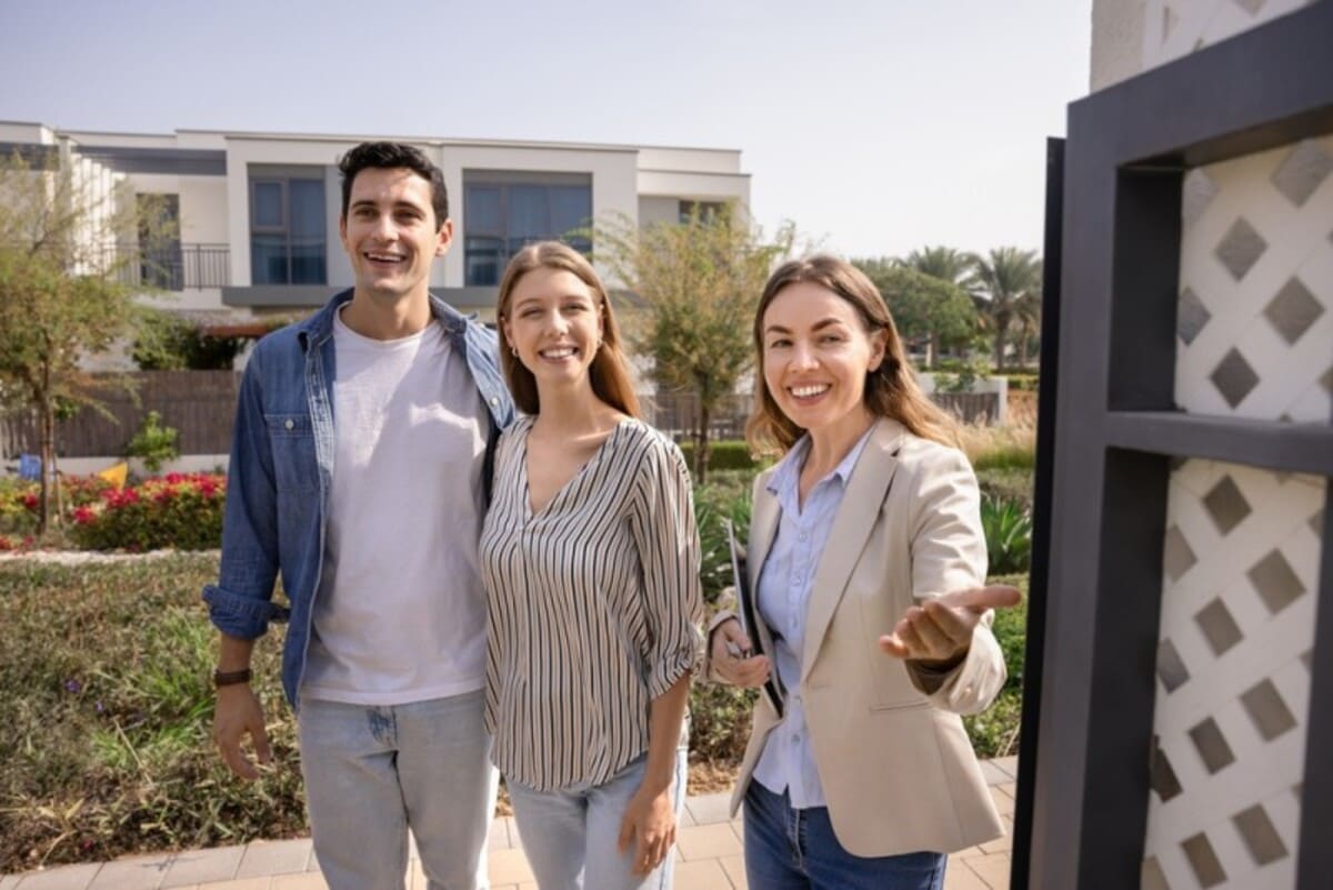 cuplu alaturi de agent imobiliar la vizionarea unei case