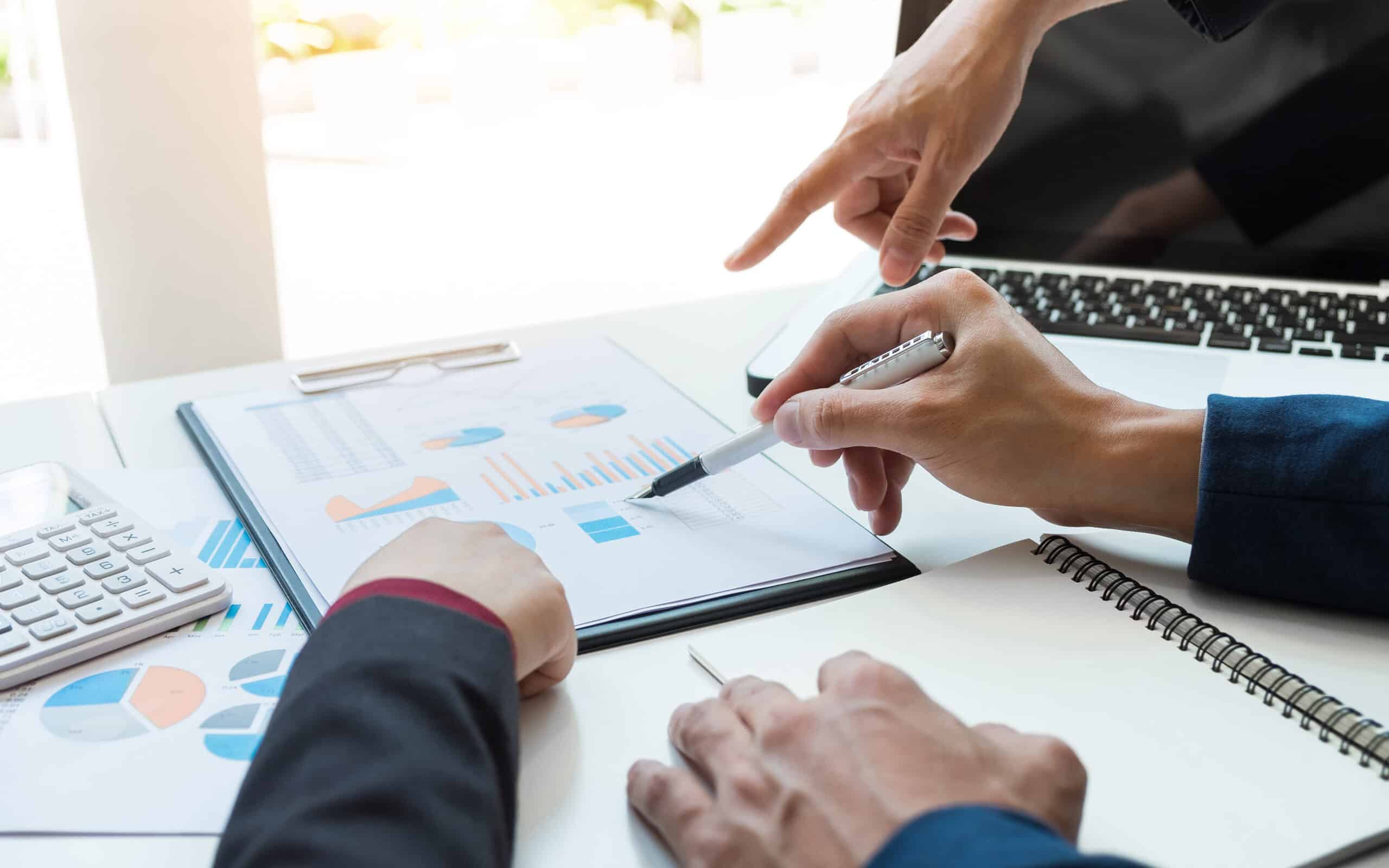 Hands pointing to employee ratio benchmarks on report