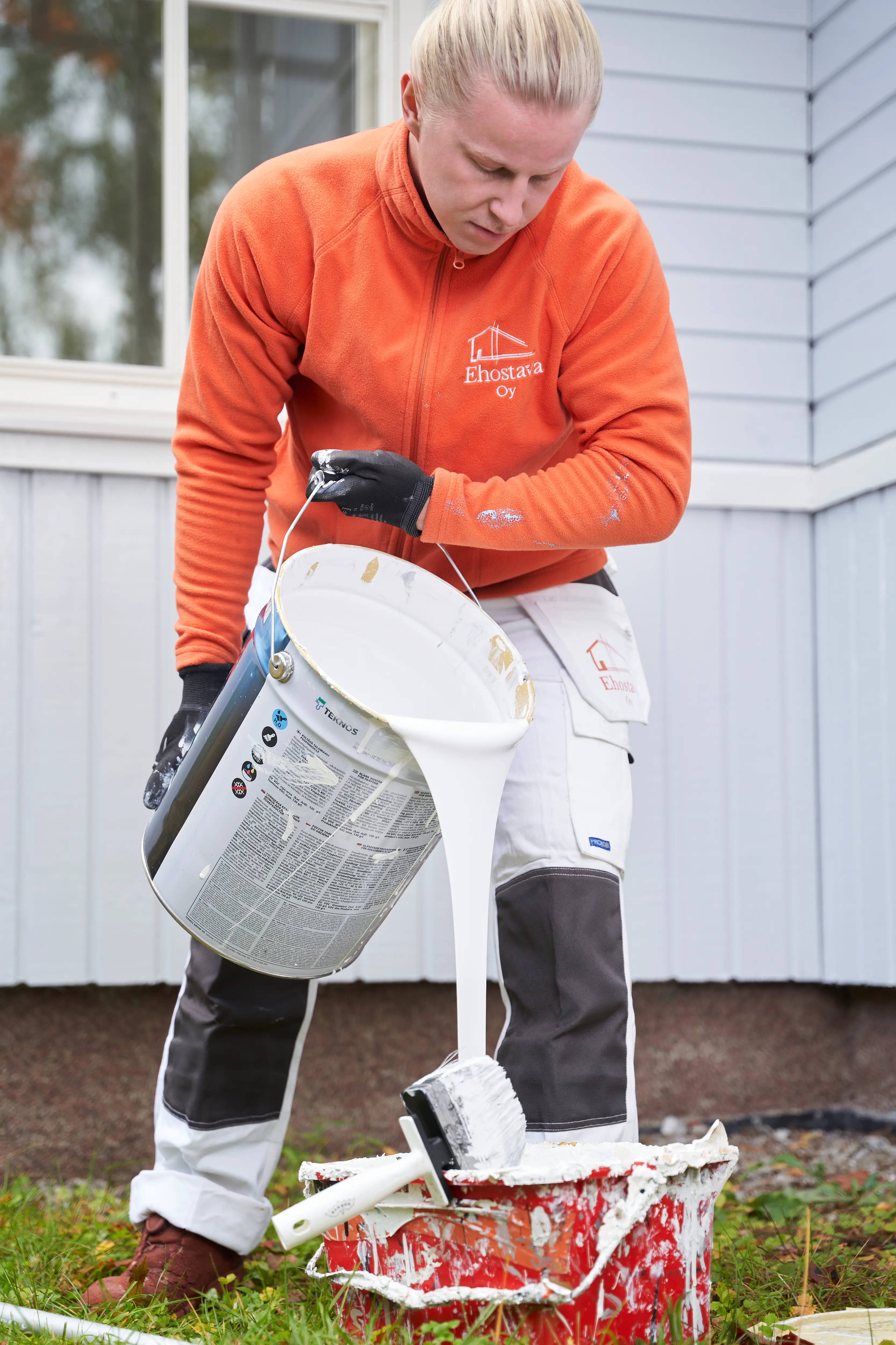 Maalari kaataa maalia lisää pönttöön.
