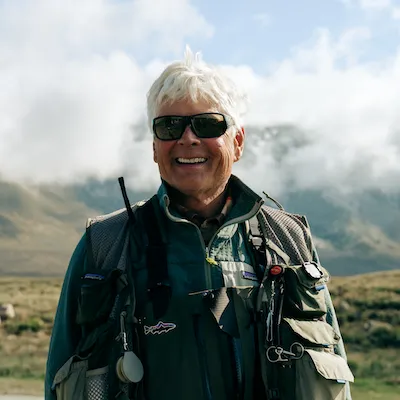 Craig Mathews smiling with fishing gear on.