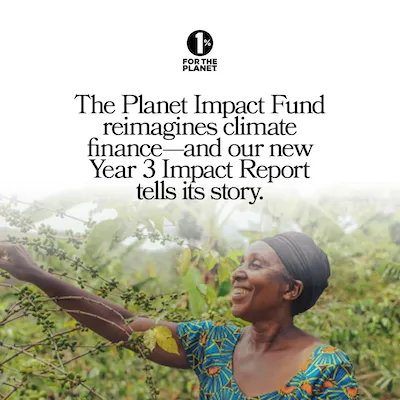 A woman smiling in front of green trees.