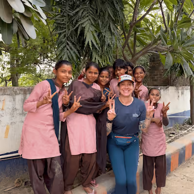 Hannah Cox showing a peace sign with kids.