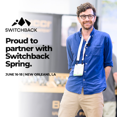 A man in a blue shirt smiling with text that says, "Proud to partner with Switchback Spring."